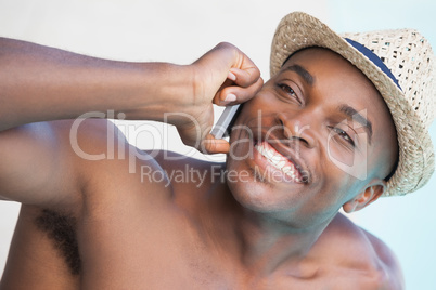 Smiling man talking on phone by the pool