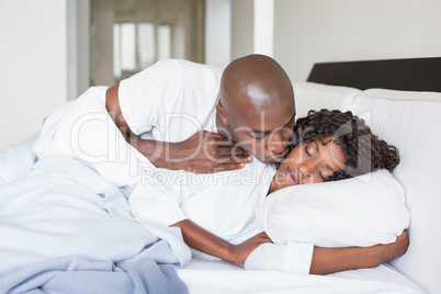 Happy couple lying in bed together