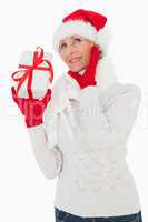 Festive woman listening and holding gift