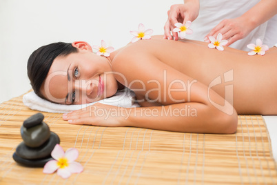 Beautiful brunette enjoying a flower back massage