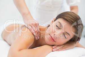 Attractive woman receiving shoulder massage at spa center