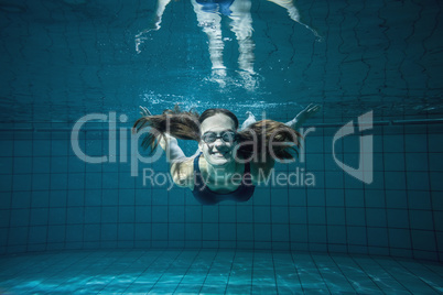 Athletic swimmer smiling at camera underwater