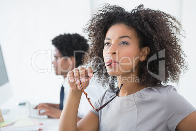 Young editor thinking at her desk