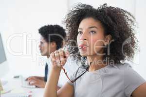 Young editor thinking at her desk