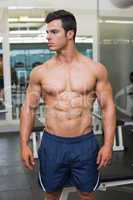 Muscular man looking away in gym