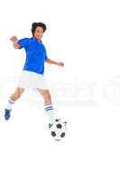 Football player in blue kicking ball