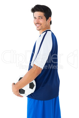 Happy football player in blue holding the ball