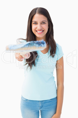 Happy young brunette holding paintbrush