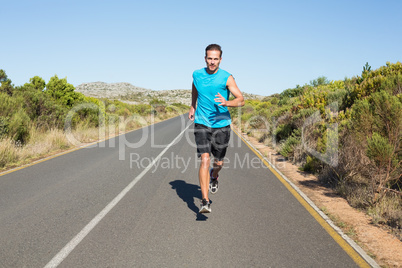 Fit man jogging on the open road