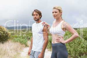 Attractive fit couple standing on mountain trail