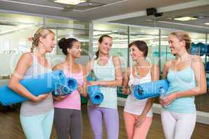 Smiling women in fitness studio before yoga class