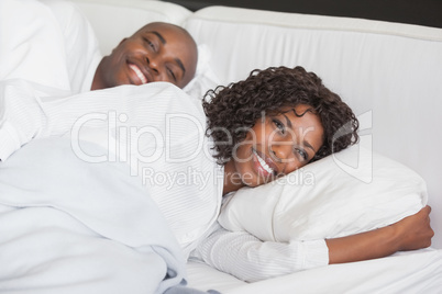 Happy couple sleeping together in bed