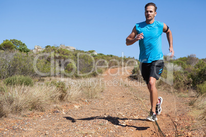 Athletic man jogging on country trail