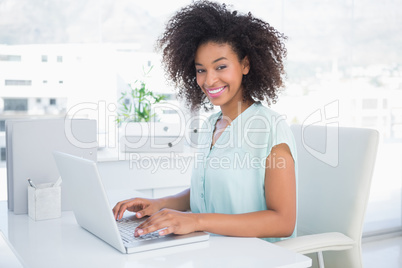 Happy businesswoman working on her laptop