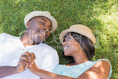 Happy couple lying in garden together on the grass
