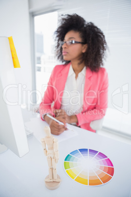 Casual graphic designer working at her desk sketching