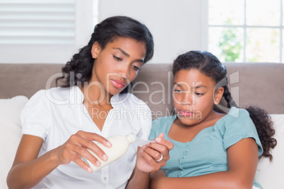 Concerned mother giving her sick daughter medicine