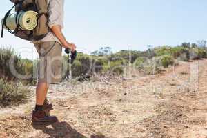 Hiker holding his binoculars on country trail