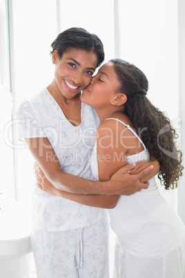 Mother and daughter embracing in the morning