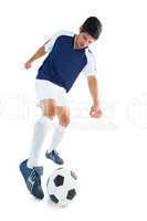 Football player in blue kicking ball