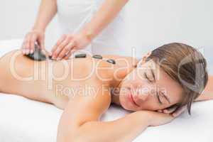 Beautiful woman receiving stone massage at spa center