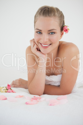 Pretty blonde lying on massage table with rose petals