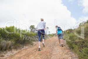 Fit attractive couple jogging up mountain trail