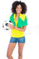 Pretty football fan with brazilian flag smiling at camera