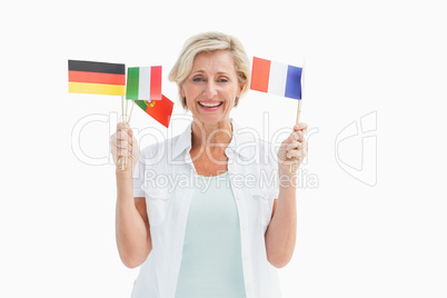 Happy mature woman holding flags