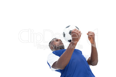 Football player in blue jersey controlling ball