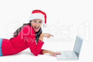 Beautiful festive woman pointing to laptop
