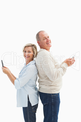 Happy mature couple using their smartphones