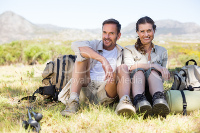 Happy hiking couple taking a break on mountain trail