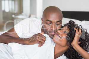 Happy couple lying in bed together