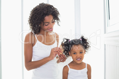 Pretty mother brushing her daughters hair Pretty mother brushing her daughters hair