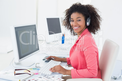 Casual photo editor working at desk smiling at camera