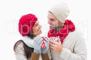 Attractive young couple in warm clothes holding mugs
