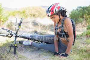 Fit woman lying on ground after bike crash
