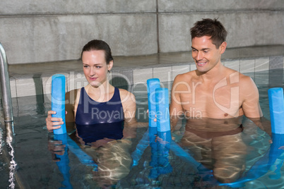 Happy couple holding foam rollers