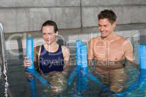 Happy couple holding foam rollers