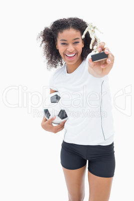 Pretty girl holding football and trophy