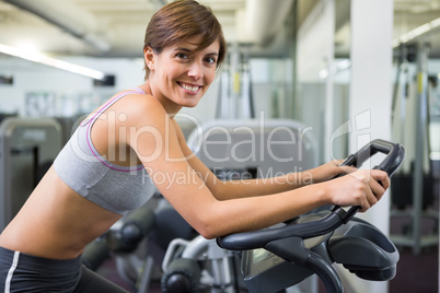 Fit brunette working out on the exercise bike