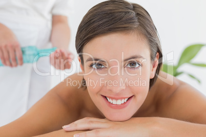 Attractive woman getting massage oil on her back