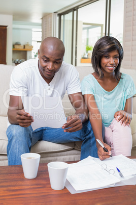 Confident couple calculating bills on the couch