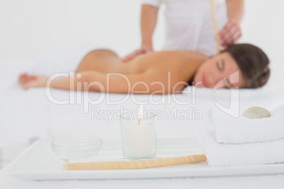 Beautiful woman receiving ear candle treatment at spa center