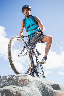 Fit man cycling on rocky terrain