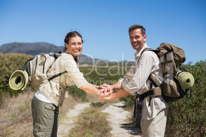 Hiking couple putting hands together on country trail