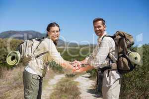 Hiking couple putting hands together on country trail