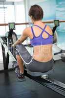 Fit brunette working out on rowing machine