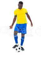 Football player in yellow kicking ball